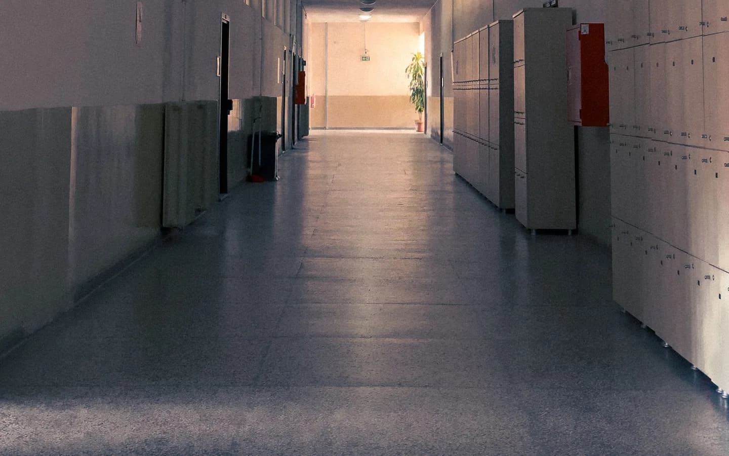 An empty school corridor lined with lockers.