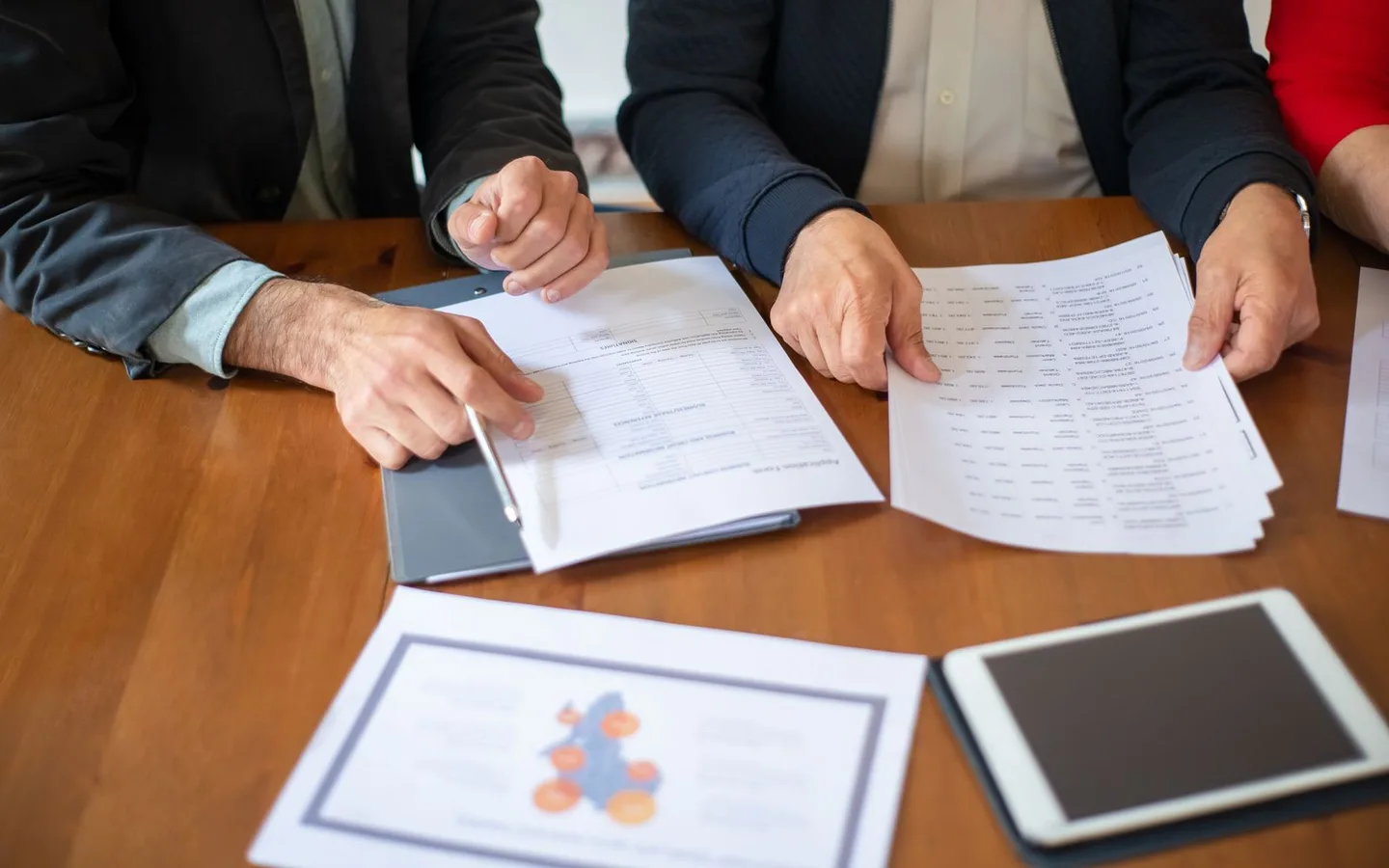 Des collègues examinent des documents autour d’une table.