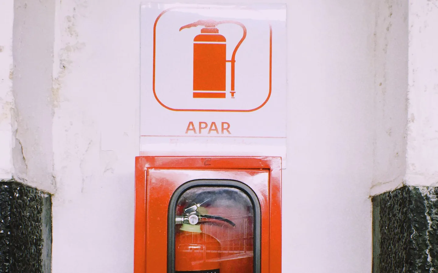 A wall-mounted fire extinguisher and safety sign.